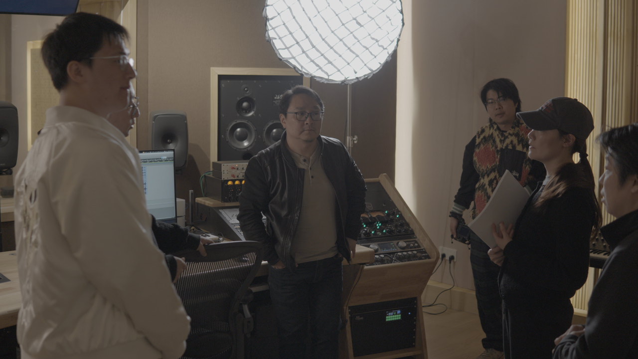 Production team gathered around the recording console